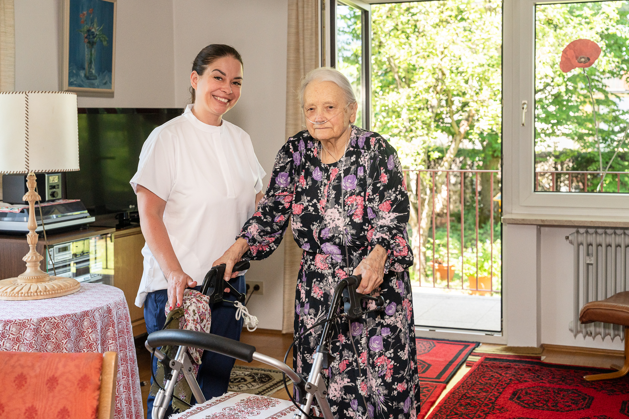 Aktivierung am Tisch: Pflegekraft mit Seniorin im Rollstuhl